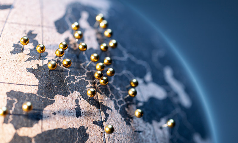 Map of Europe on a globe with golden pins in each country