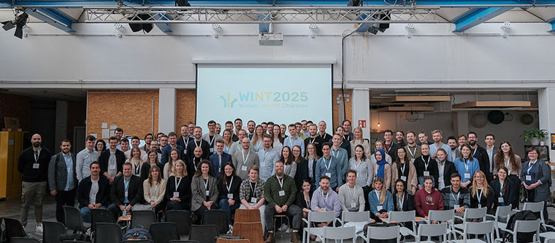 WI-Nachwuchstreffen-2025, Gruppenfoto mit ca. 80 Personen in einer Halle