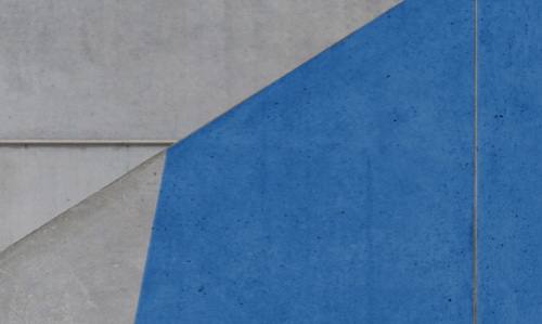 Blaue Farbe ersteckt sich diagonal in der unteren Hälfte über eine Betonwand. Die blaue Farbe ist in der linken unteren Ecke abgeschnitten