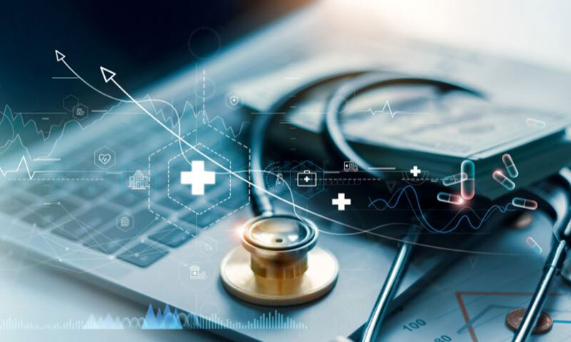 Stethoskop liegt auf Laptop-Tastatur mit eingeblendeten medizinischen Symbolen und Diagrammen