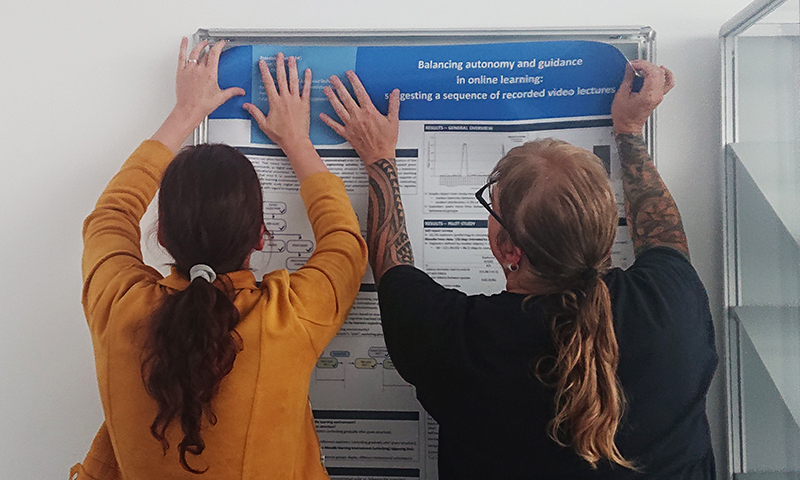 Sandra Kirschbaum und Manuela Oertwig befestigen das CATALPA-Poster von Franziska Wehrhahn