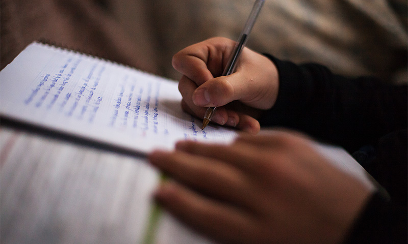 Hände beim handschriftlichen Notieren eines Textes.