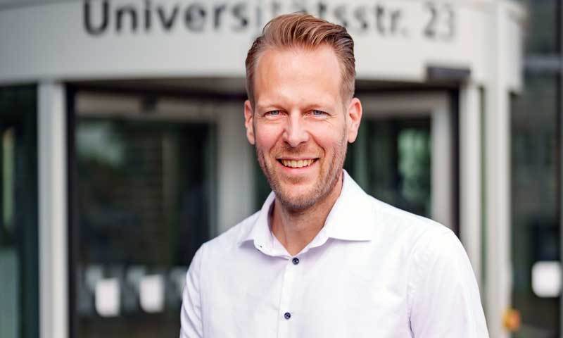 Photo of Dr. Michael Bucksteeg smiling outside a university building