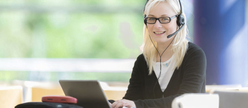 Frau mit Headset am Laptop