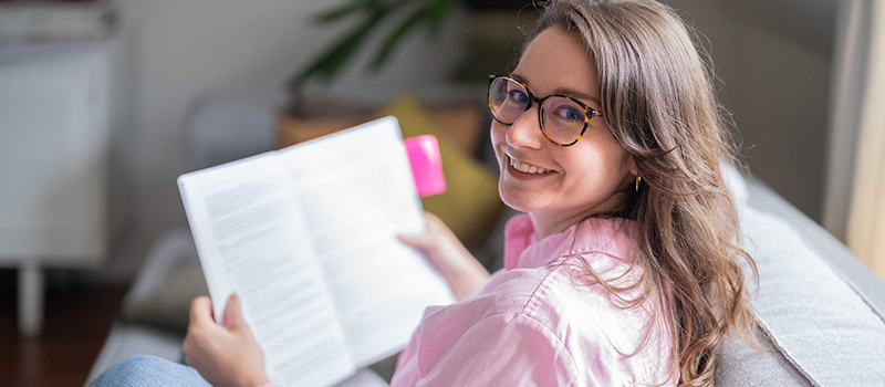 Studentin auf den Sofa mit Studienunterlagen