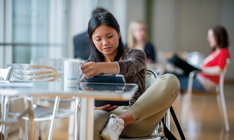Studentin mit Tablet an Tisch