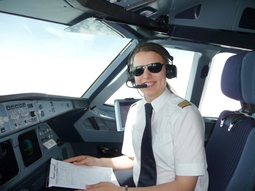 Eine Frau sitzt im Cockpit eines Flugzeuges.