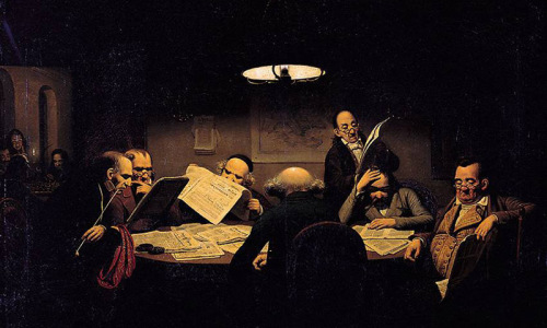 Mehrere Männer in der Kleindung des 19. Jahrhunderts sitzen in einem recht dunklen Raum lesend an einem Tisch.