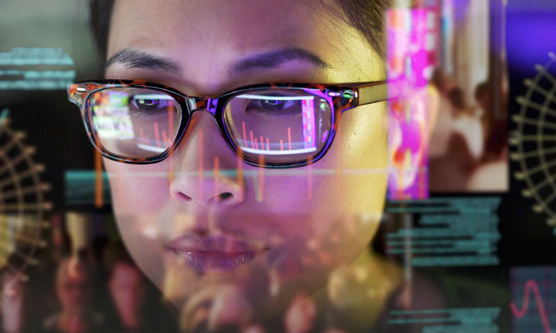 Frau mit Brille schaut auf holografische Statistiken