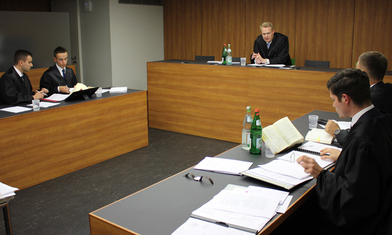 Verhandlungssituation mit vier jungen Teilnehmenden und Richter
