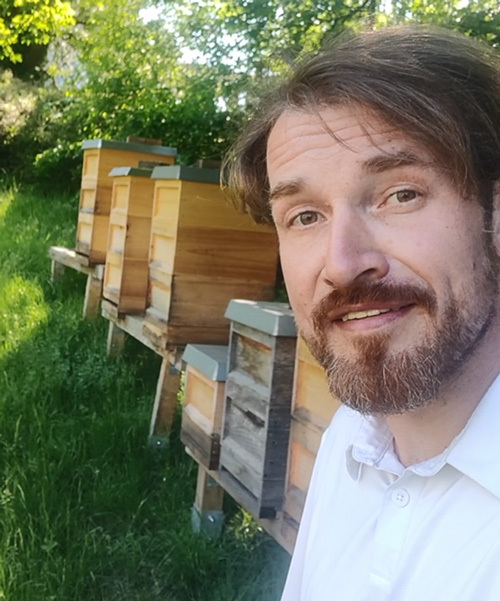 Markus Kroll vor Bienenstöcken