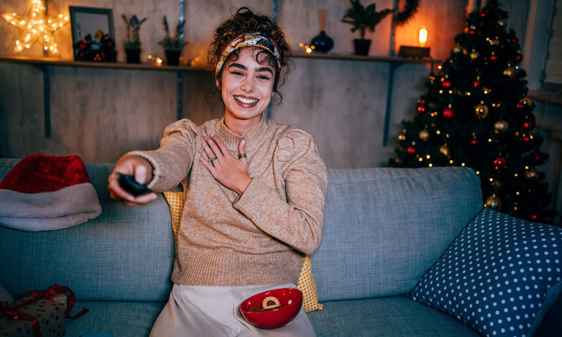 Frau mit Fernbedienung auf Couch