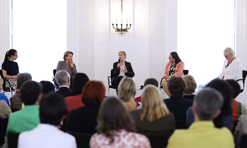 Fünf Frauen sitzen auf einem Podium.