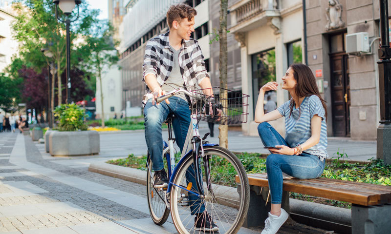 Fahrradfahrer unterhält sich mit Frau auf der Straße