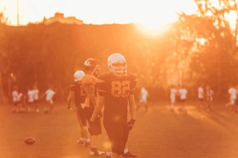 Football-Spieler steht auf dem Feld. Es scheint die Sonne