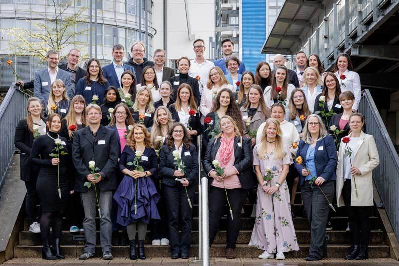 Eine Gruppe Menschen steht auf einer Treppe am Campus in Hagen