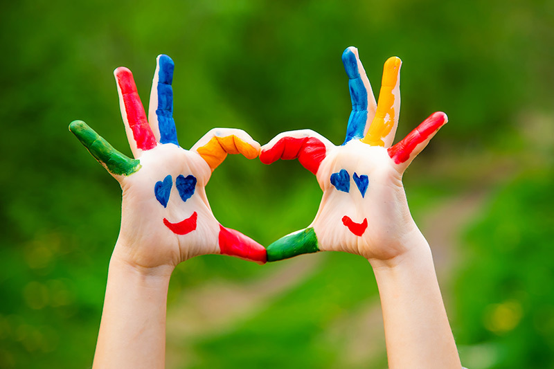 Bunte Kinderhände formen ein Herz