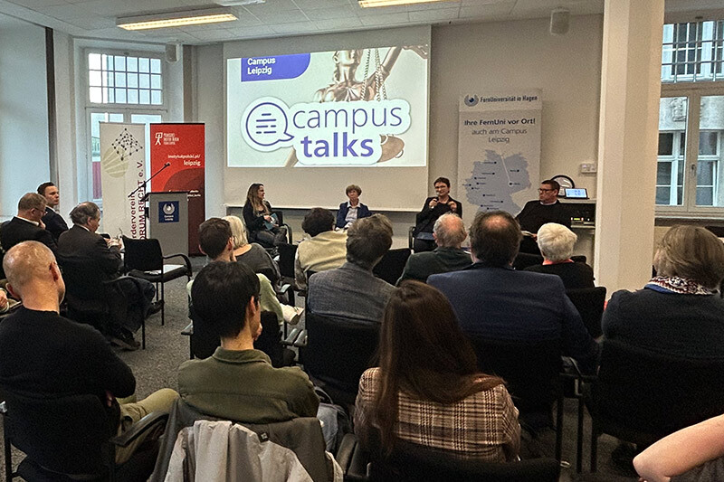 Blick über das Publikum hinweg auf die Beteiligten der Podiumsdiskussion bei den ersten Leipziger Campus Talks