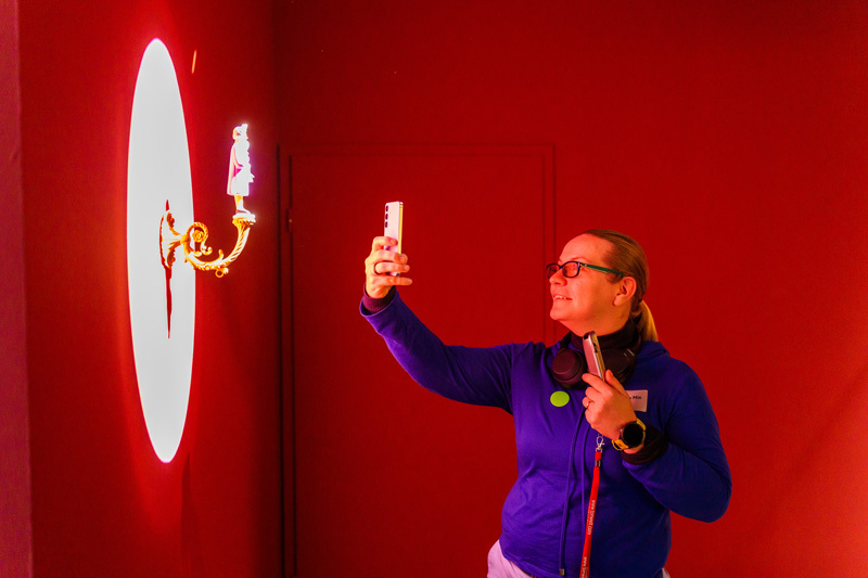 Frau fotografiert Ausstellungsstück mit Smartphone