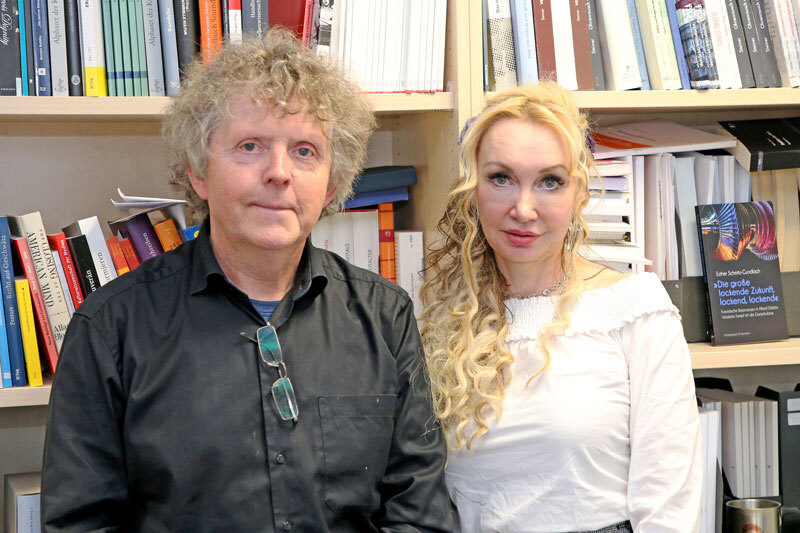 Zwei Menschen vor Bücherregal