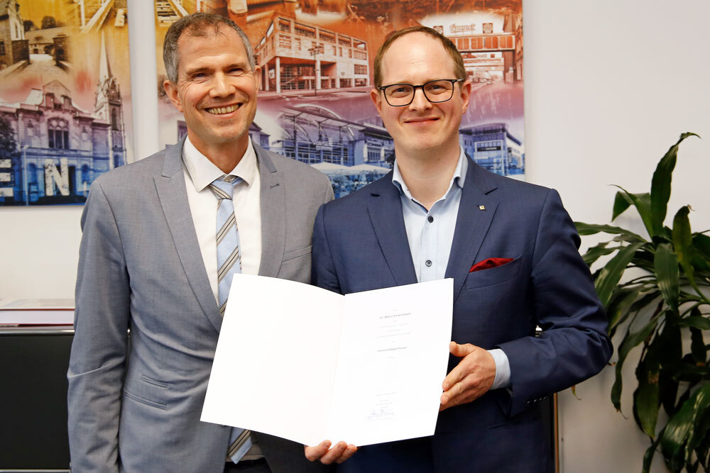 Männer mit Urkunde, lächelnd