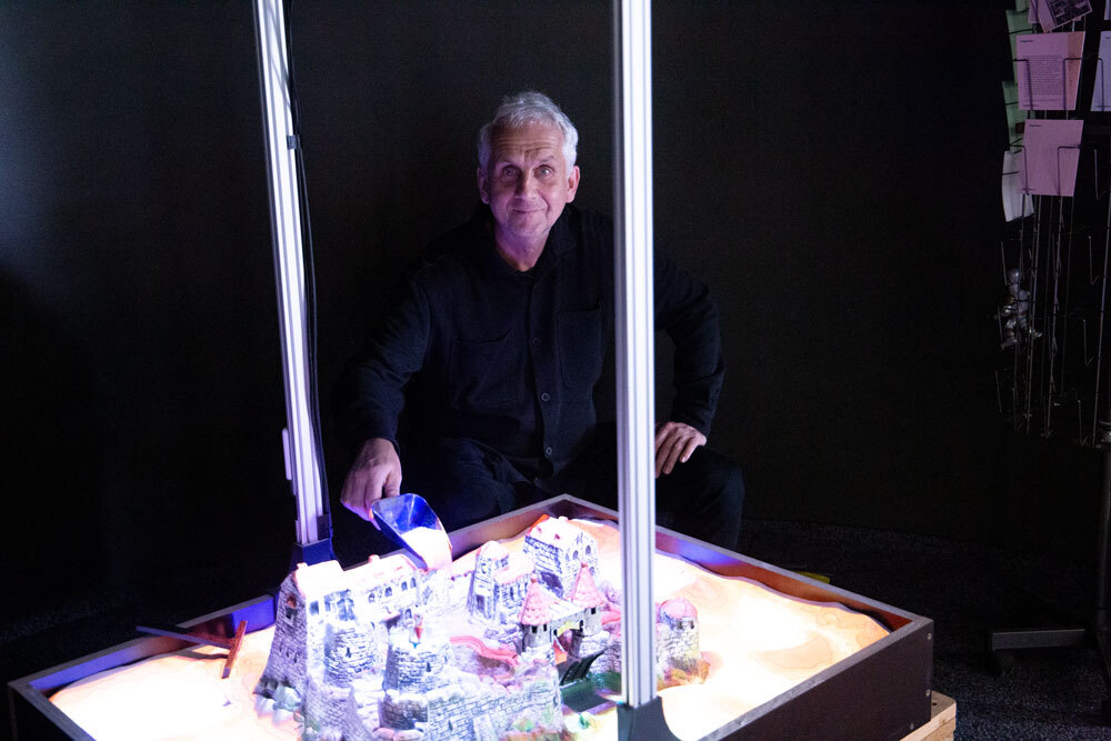 Mann mit Spielzeugritterburg in AR-Sandkasten
