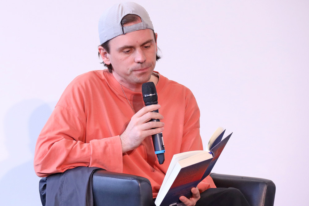 Mann liest aus Buch vor