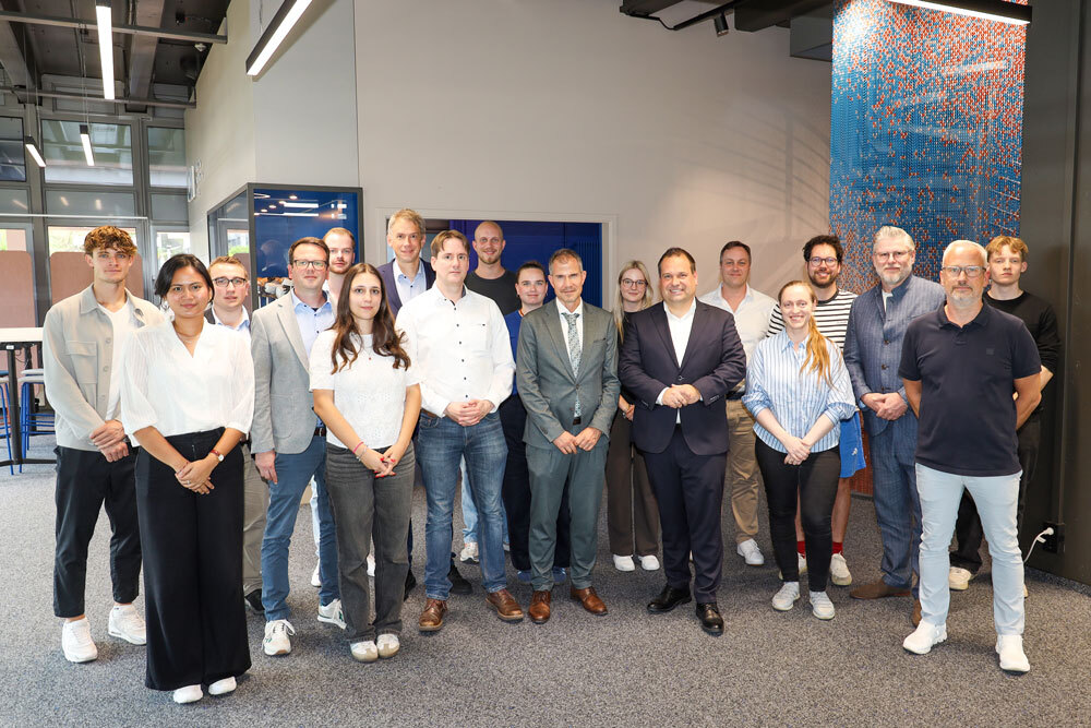 Gruppenbild der Besucher:innen mit Rektor Stürmer und Oberbürgermeister Rehbein im ICH