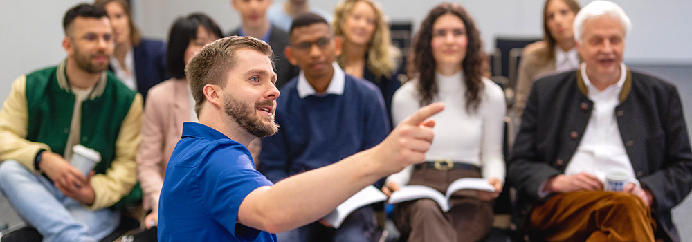 Ein Mitarbeiter der FernUniversität erklärt Studieninteressierten das Fernstudium