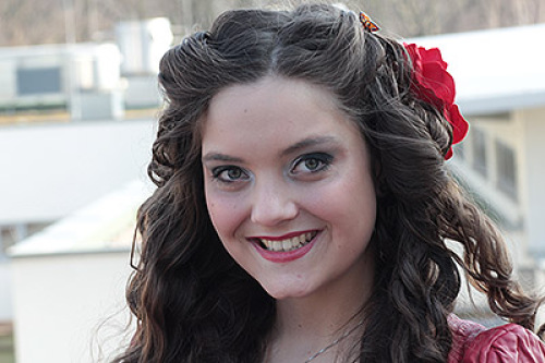 Ein junge Frau mit roter Blume im Haar