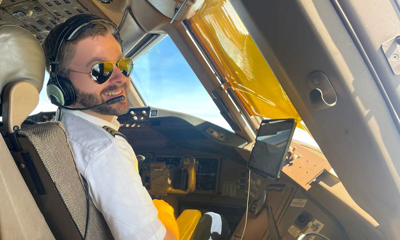 Mann in Pilotenuniform im Flugzeug-Cockpit