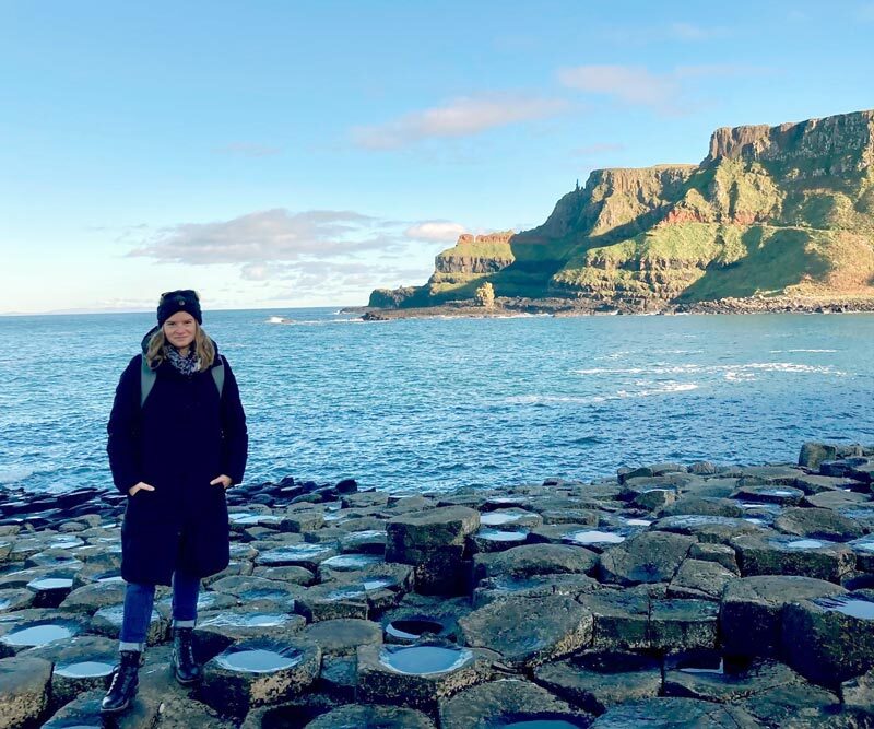 Manuela Wienhauer steht auf Felsen am Meer.