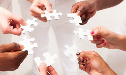 Hands holding puzzle pieces
