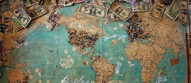 Map of the world with bank notes scattered around the edges
