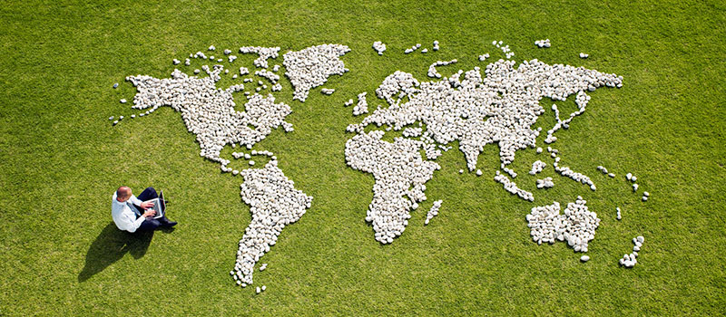 World map made of rocks on lawn