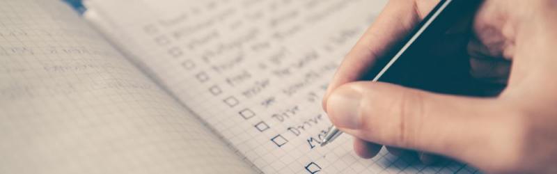 A hand writing a checklist