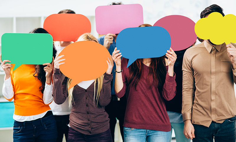 Group of people holding speech bubbles in front of their faces