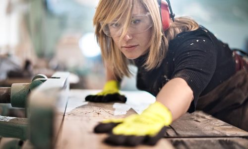 junge Frau arbeitet an Werkbank