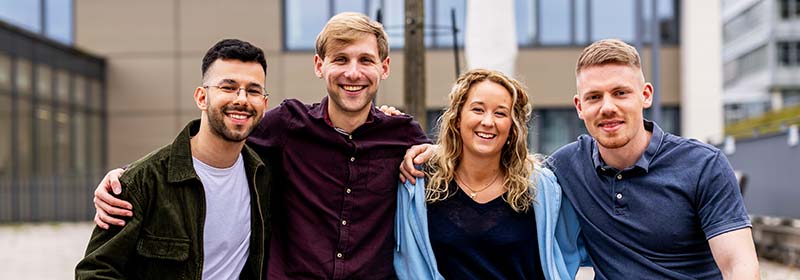 Studierende im Fernstudium sitzen auf den Stufen des FernUni-Campus