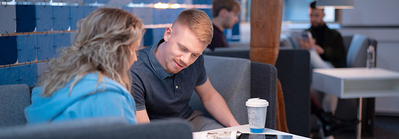 Two students working closely together on a paper