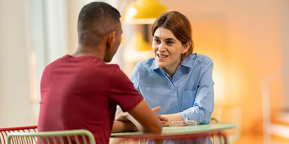 Zwei Personen sitzen an einem Tisch
