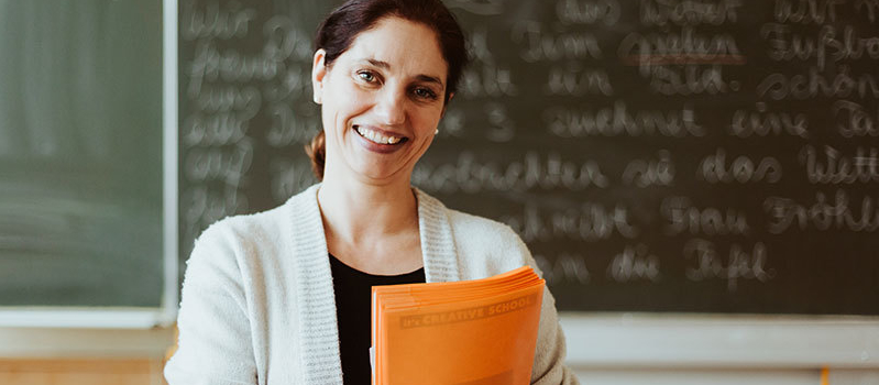 eine Frau vor der Klassentafel