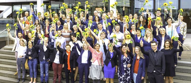 Gruppe von Ehemaligen auf einer Freitreppe vor dem Campus