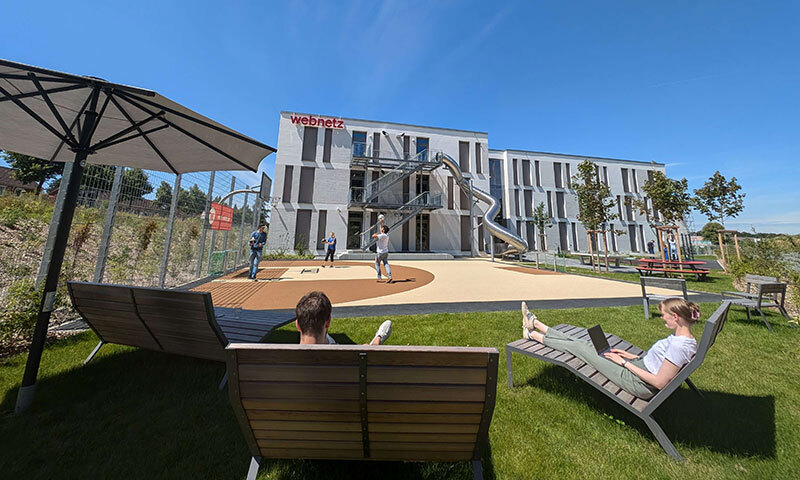 Gebäude und ein Spielplatz mit Rutsche und Sitzbänke