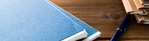 Häfte mit dicken blauen Umschlägen, Kugelschreiber, Aktentaschen.