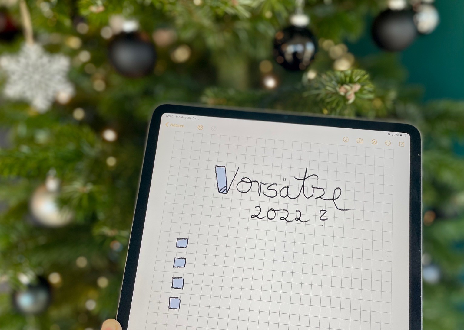 Vorsatzliste auf Tablet PC vor einem Christbaum