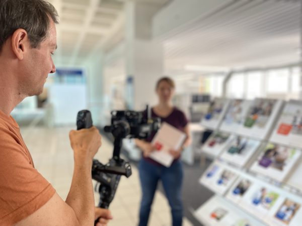 Videoaufnahmen mit einer Gimbal Kamera im Vordergrund Kameramann im Hintergrund unscharf agierende Person in der UB Hagen