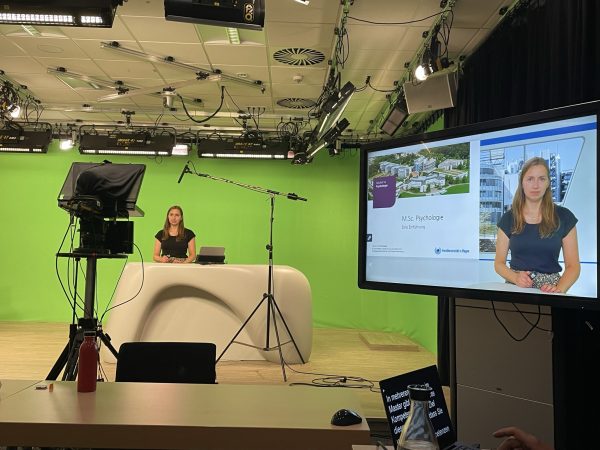 Videostudio Setting mit Teleprompter, Teilnehmende im Greenscreen Studio, danaben ein Bildschirm auf dem das fertige Bild mit Hintergrund angezeigt wird