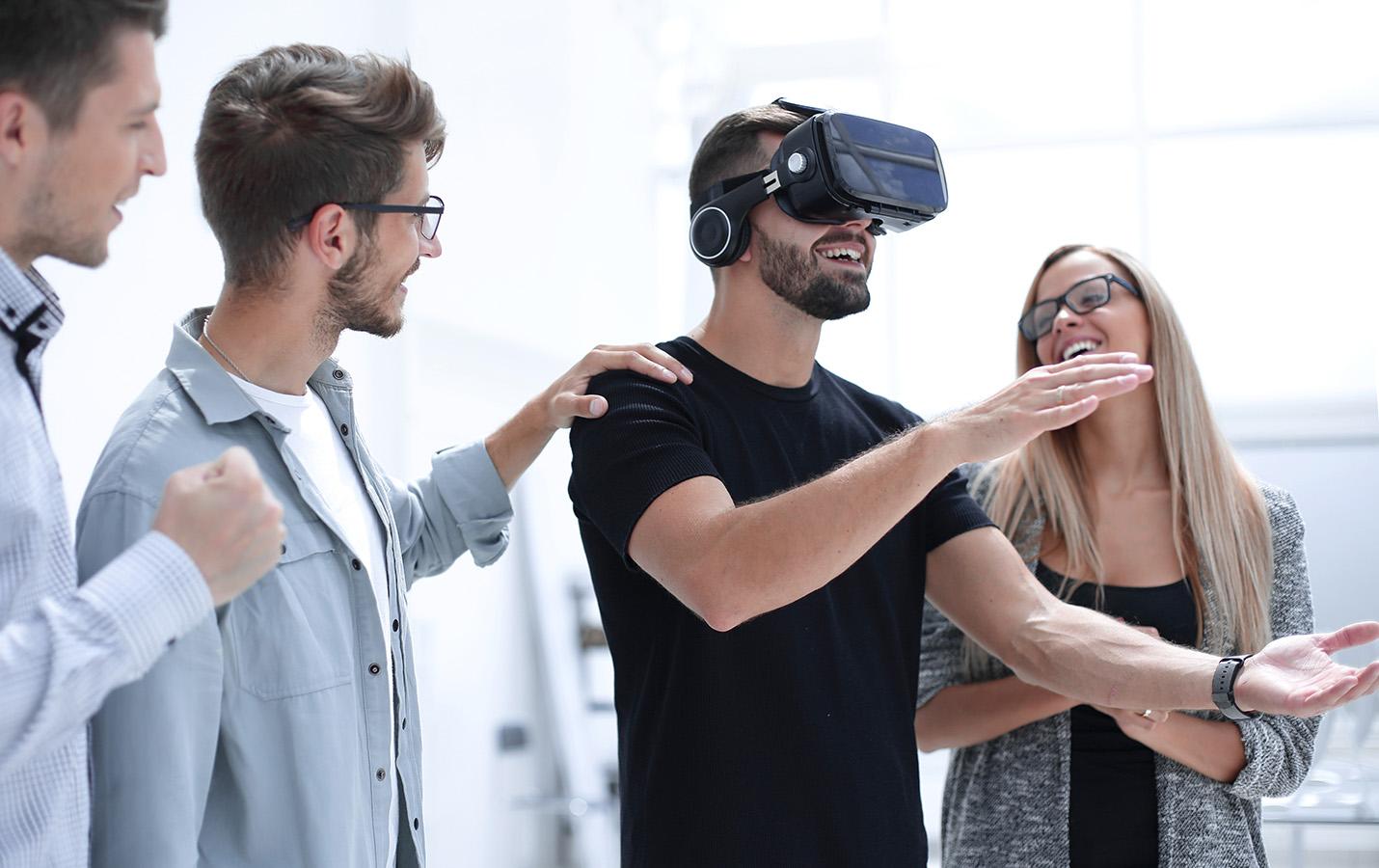 Vier Personen, von denen eine eine VR-Brille trägt